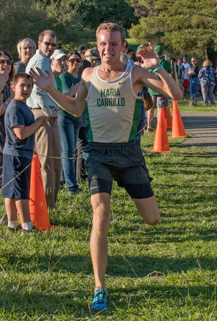 Athlete prepares for pole vault on a track with others watching.