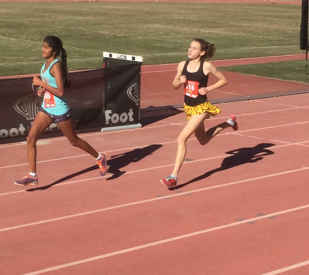 Athlete prepares for pole vault on a track with others watching.