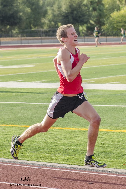 Athlete prepares for pole vault on a track with others watching.