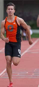 Athlete prepares for pole vault on a track with others watching.