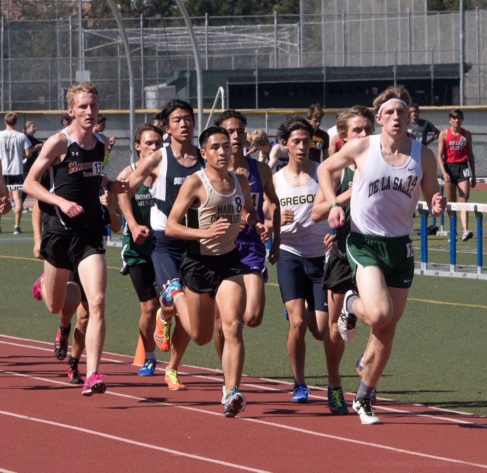 Athlete prepares for pole vault on a track with others watching.