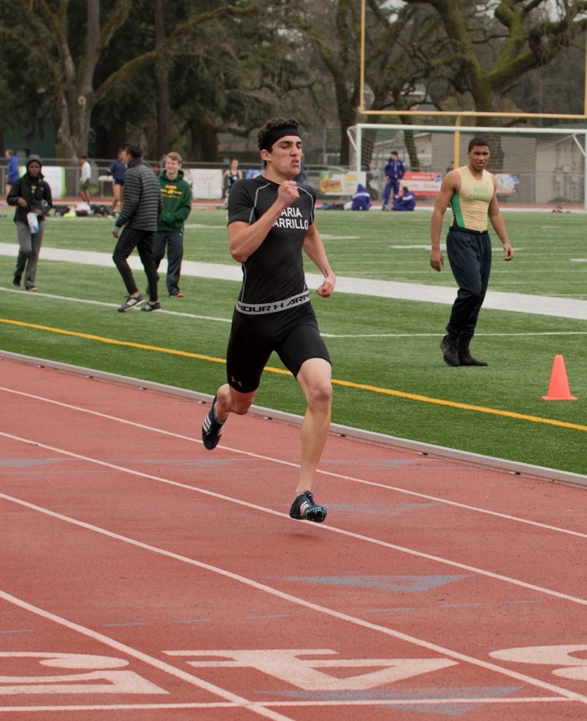 Athlete prepares for pole vault on a track with others watching.