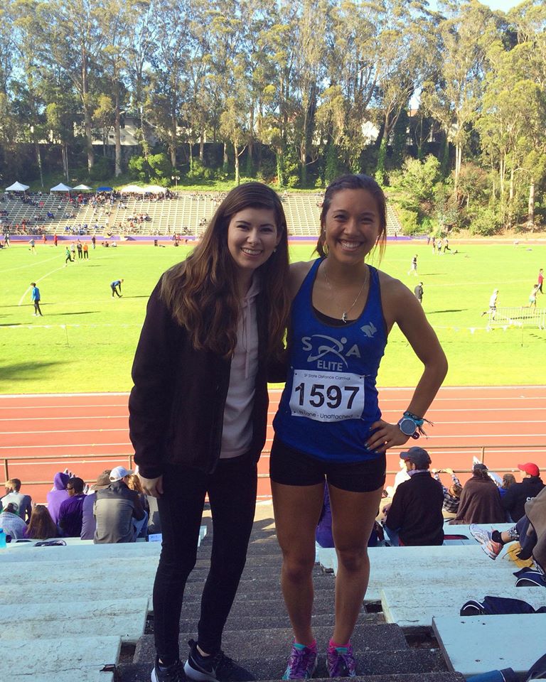 Athlete prepares for pole vault on a track with others watching.