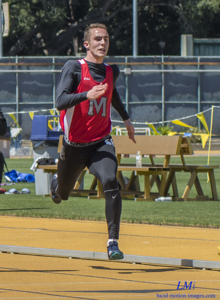 Athlete prepares for pole vault on a track with others watching.