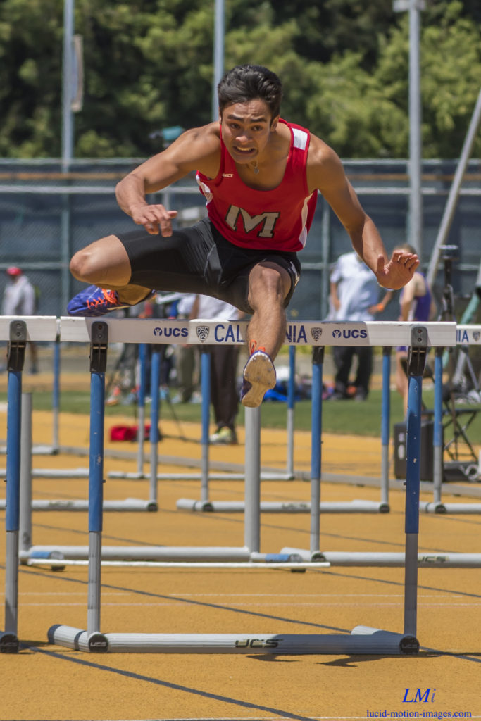Athlete prepares for pole vault on a track with others watching.