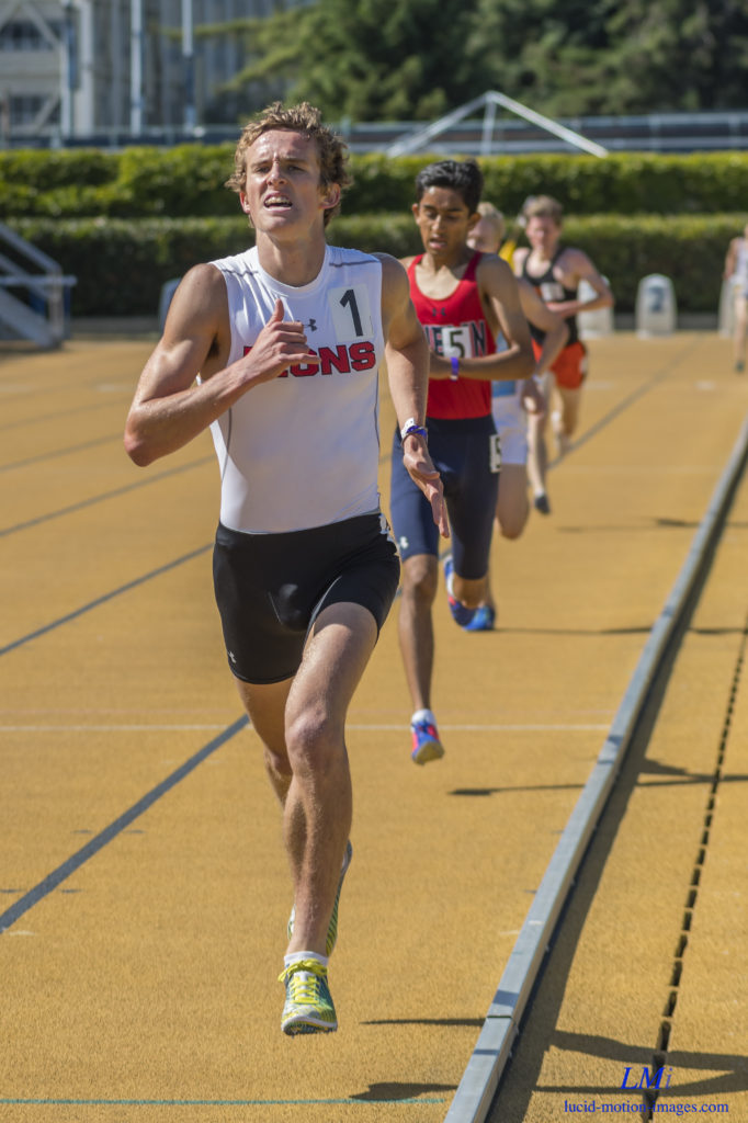 Athlete prepares for pole vault on a track with others watching.