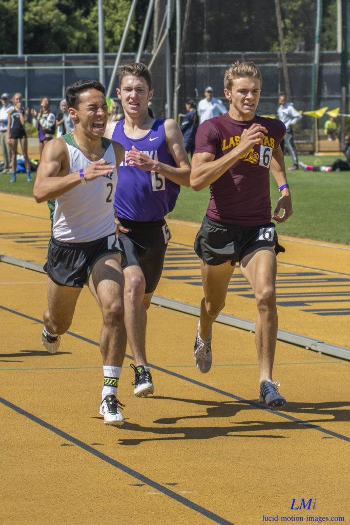 Athlete prepares for pole vault on a track with others watching.