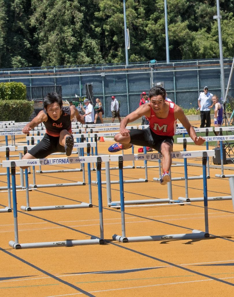 Athlete prepares for pole vault on a track with others watching.