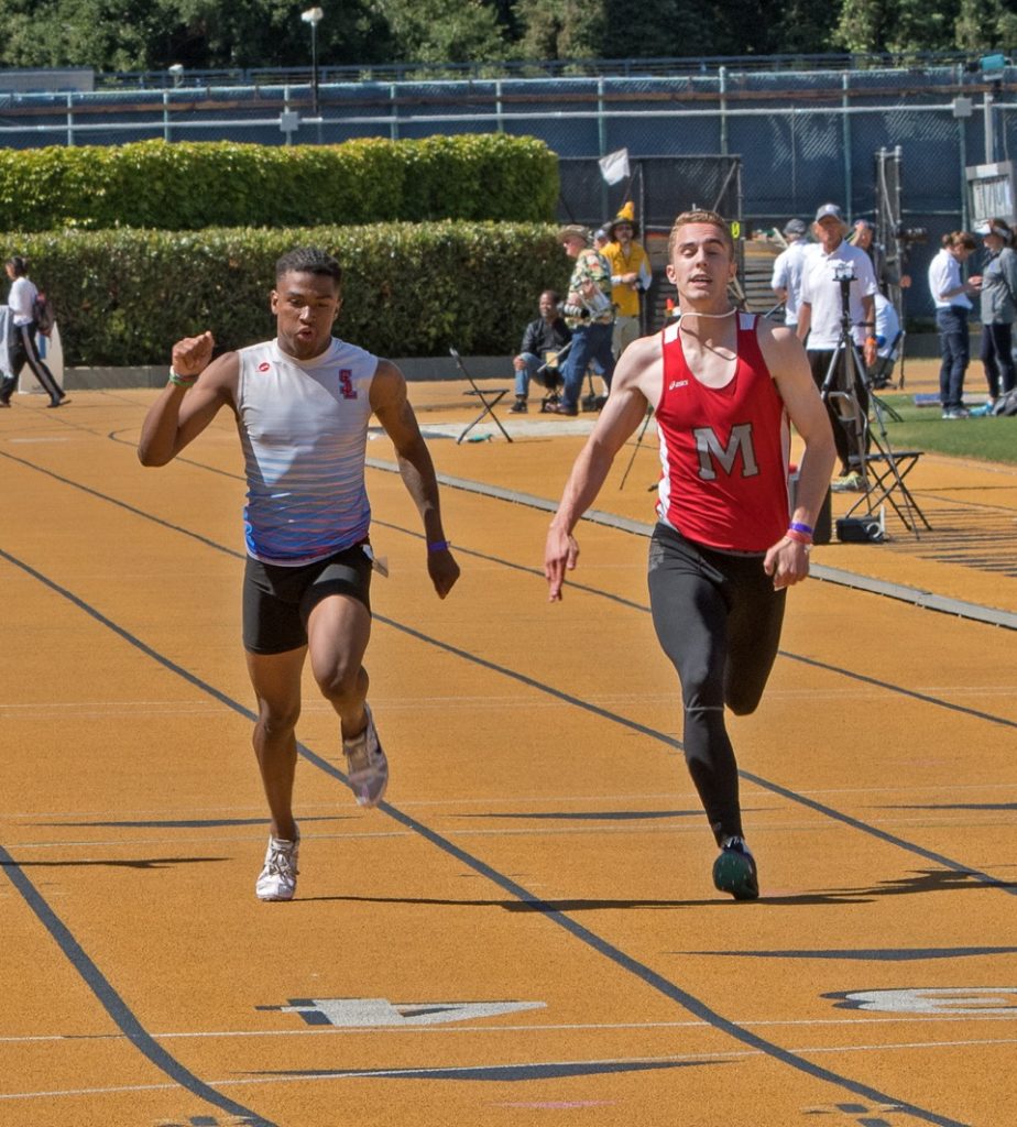 Athlete prepares for pole vault on a track with others watching.