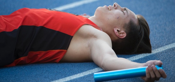 Athlete prepares for pole vault on a track with others watching.
