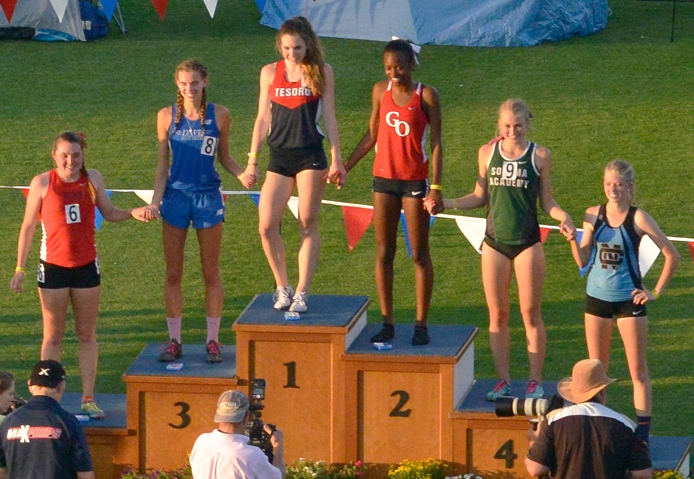 Athlete prepares for pole vault on a track with others watching.