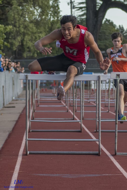 Athlete prepares for pole vault on a track with others watching.