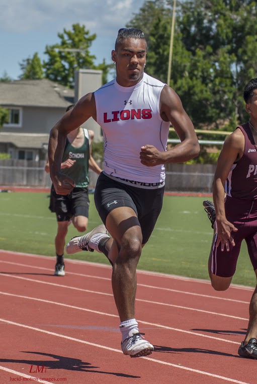Athlete prepares for pole vault on a track with others watching.