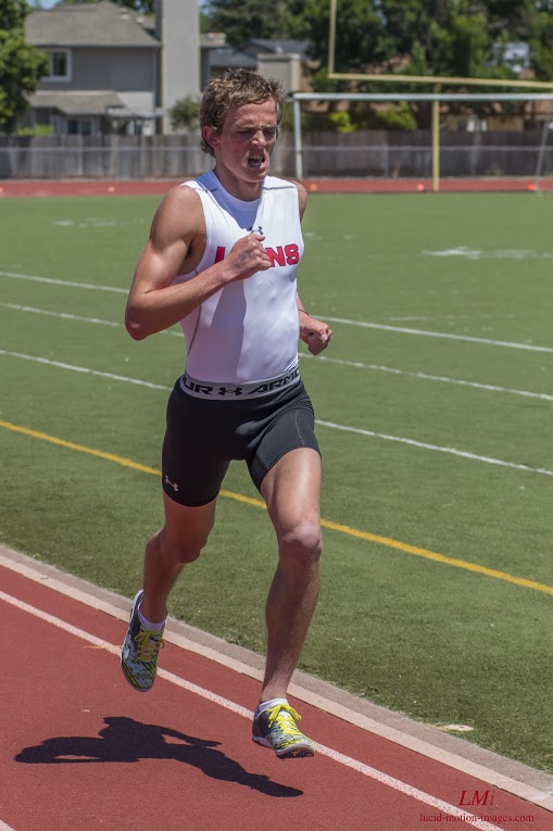 Athlete prepares for pole vault on a track with others watching.