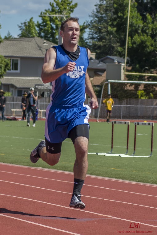 Athlete prepares for pole vault on a track with others watching.