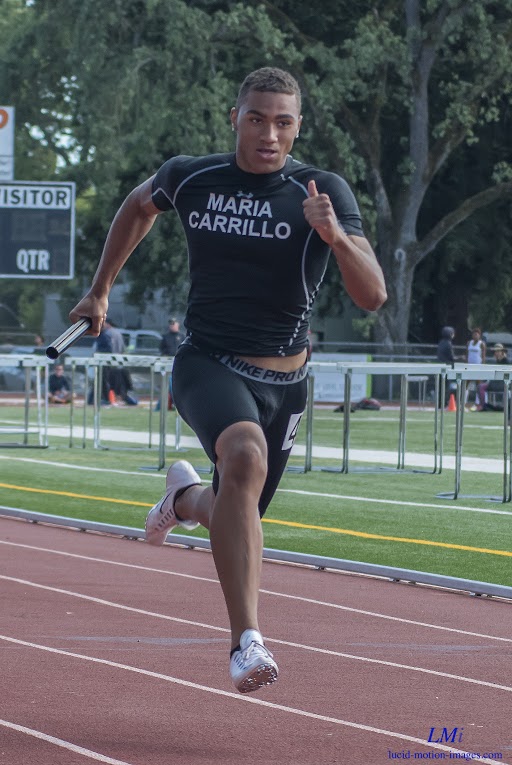 Athlete prepares for pole vault on a track with others watching.