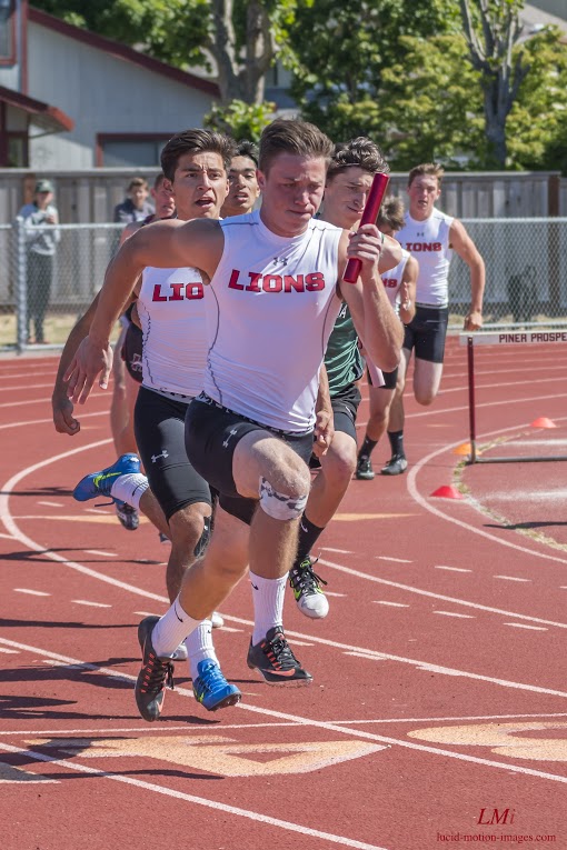 Athlete prepares for pole vault on a track with others watching.