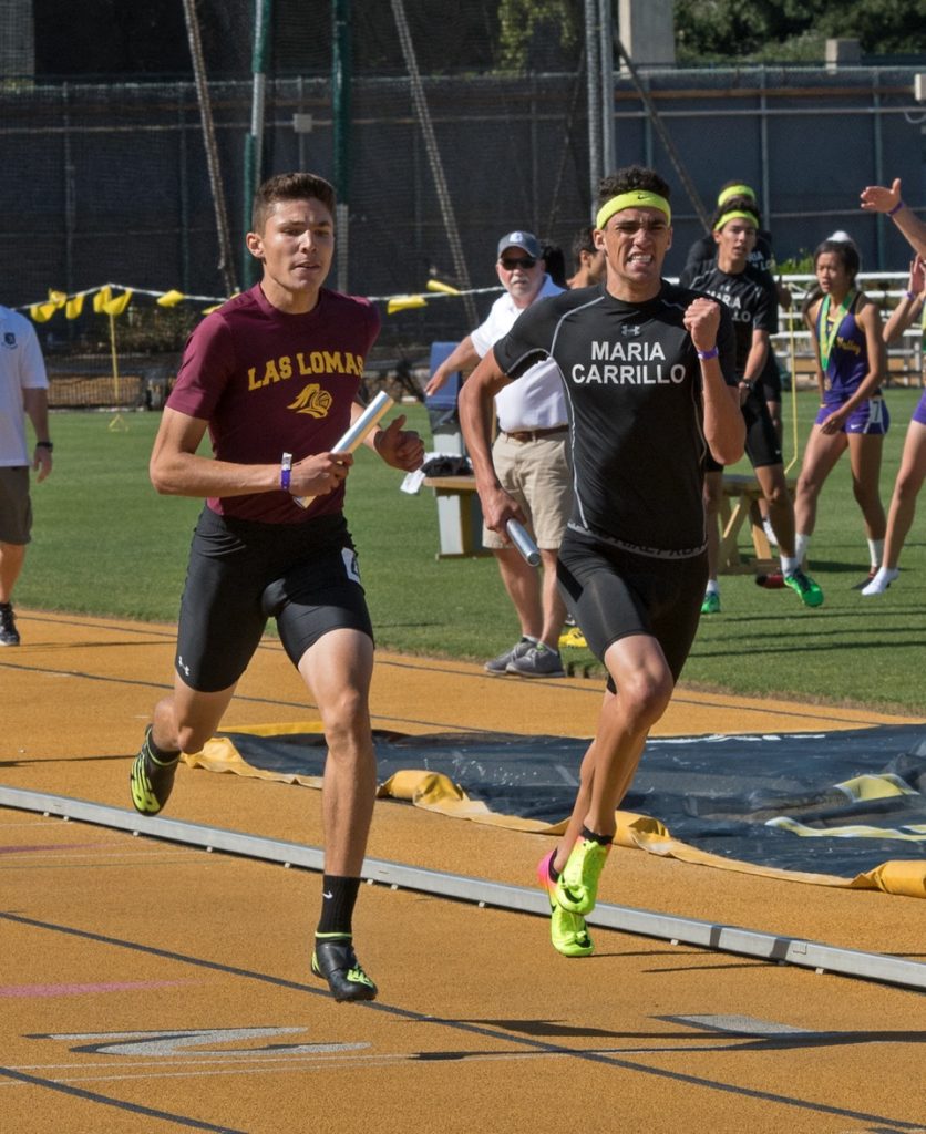 Athlete prepares for pole vault on a track with others watching.