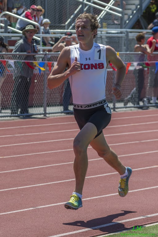 Athlete prepares for pole vault on a track with others watching.