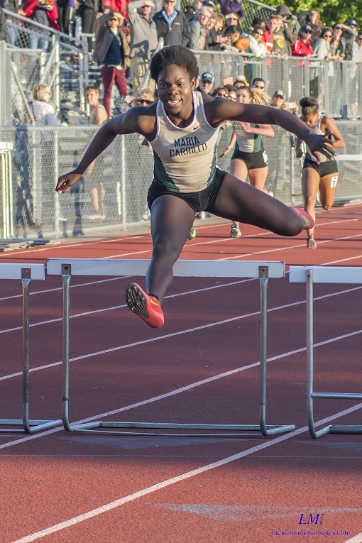 Athlete prepares for pole vault on a track with others watching.