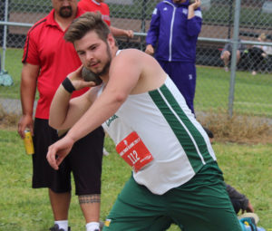 Male athlete preparing for a shot put throw during a track and field event.
