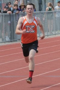 Young athlete running on a track during a race.