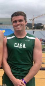 Young athlete in a green CASA sports jersey smiling outdoors.