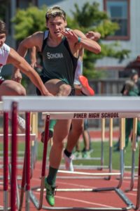 Athlete jumping over a hurdle during a track event.