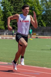 Athlete sprinting on a track wearing a white and blue Arizona Wildcats jersey.