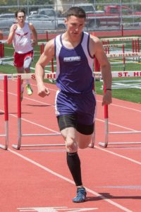 Athlete sprinting on a track during a hurdle race.