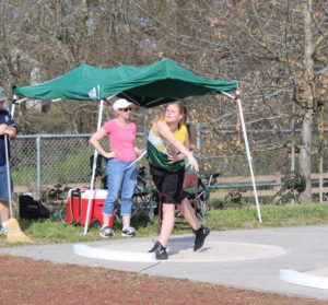 Woman preparing to throw a discus in an outdoor sports event.