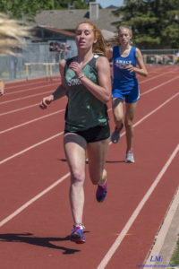 A female athlete running on a track during a race.