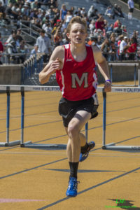 Athlete prepares for pole vault on a track with others watching.