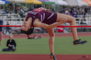 Athlete performing a high jump during a track event.