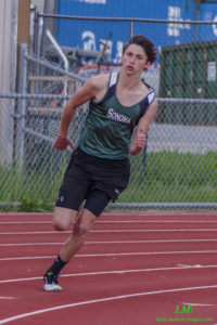 Young male athlete running on a track during a race.
