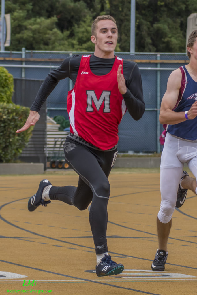 Athlete prepares for pole vault on a track with others watching.