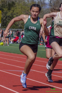 Two female athletes sprinting on a track during a race.