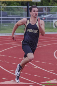 Male athlete sprinting on a track wearing Davidson tank top.