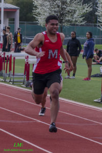 Athlete prepares for pole vault on a track with others watching.