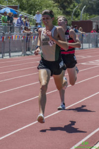 Two male athletes sprinting on a red track during a race.