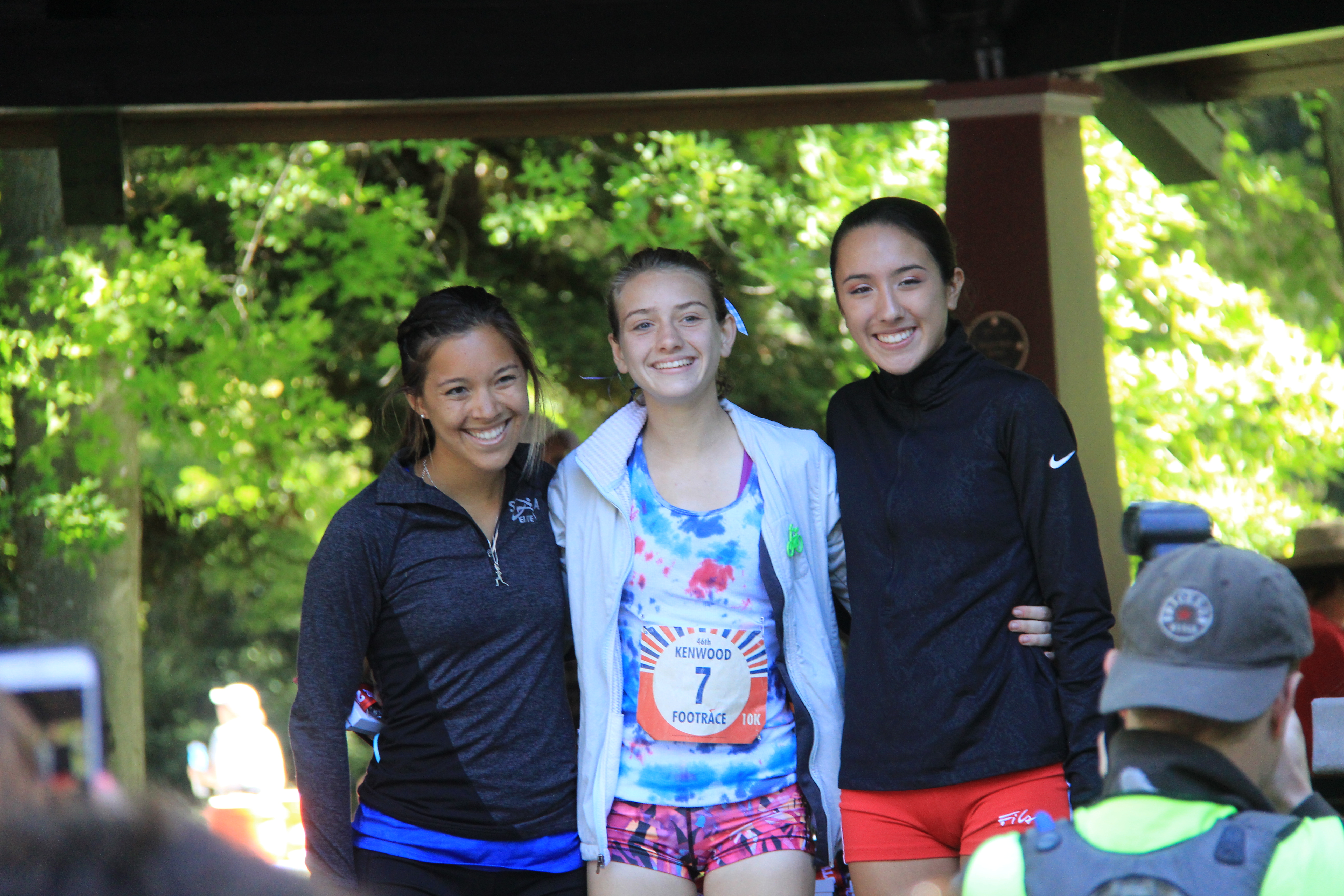 Athlete prepares for pole vault on a track with others watching.