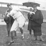 Athlete prepares for pole vault on a track with others watching.
