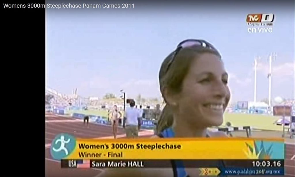 Athlete prepares for pole vault on a track with others watching.