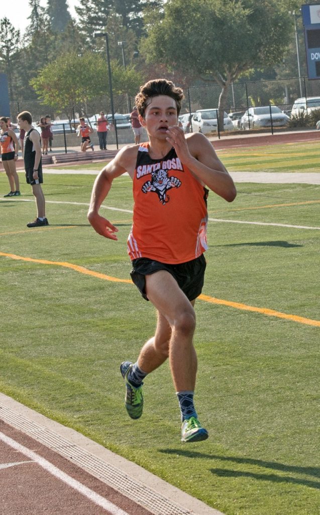 Athlete prepares for pole vault on a track with others watching.