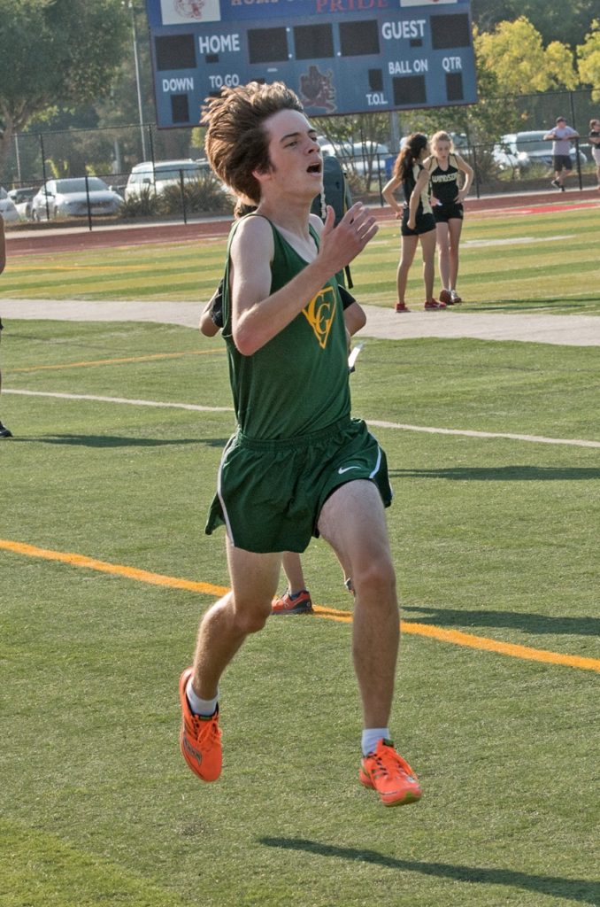 Athlete prepares for pole vault on a track with others watching.