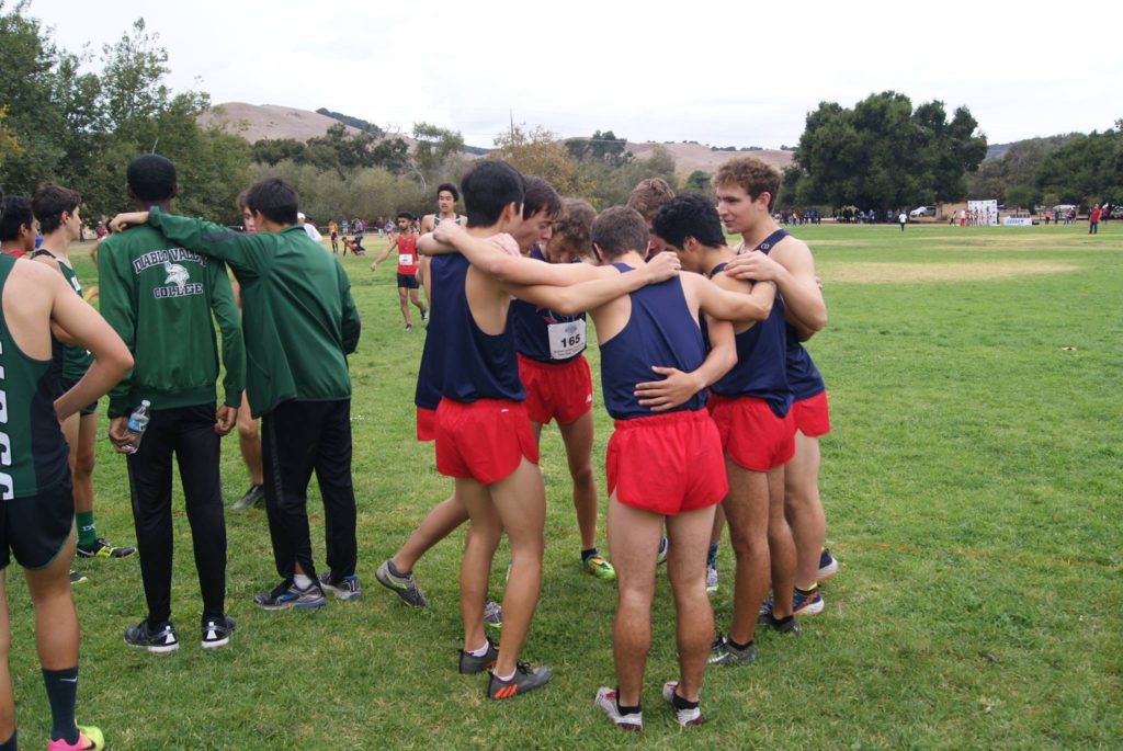 Athlete prepares for pole vault on a track with others watching.