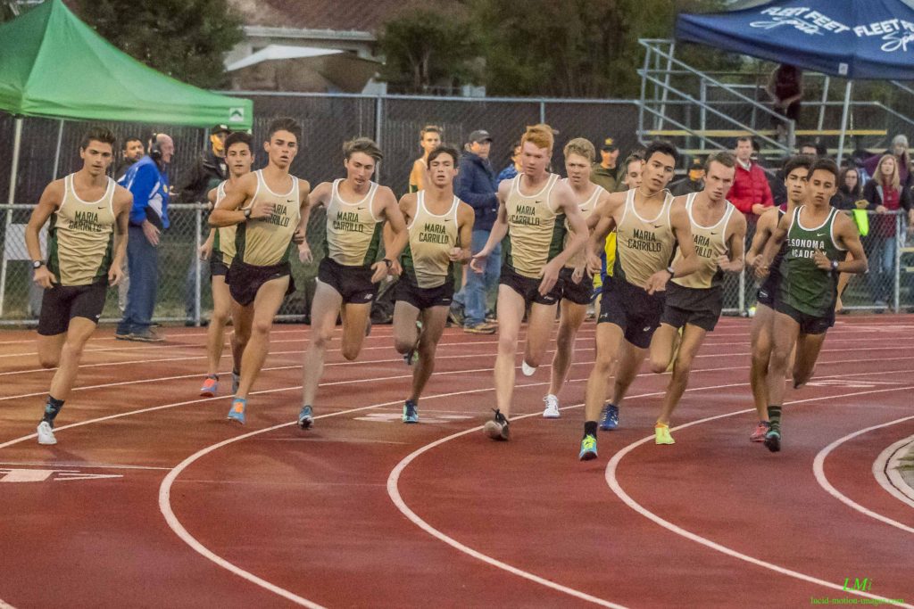Athlete prepares for pole vault on a track with others watching.