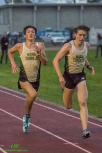 Athlete prepares for pole vault on a track with others watching.