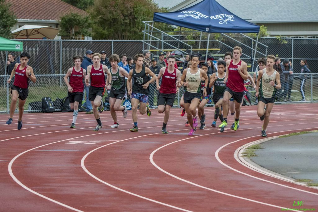 Athlete prepares for pole vault on a track with others watching.
