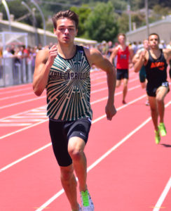 Athlete prepares for pole vault on a track with others watching.